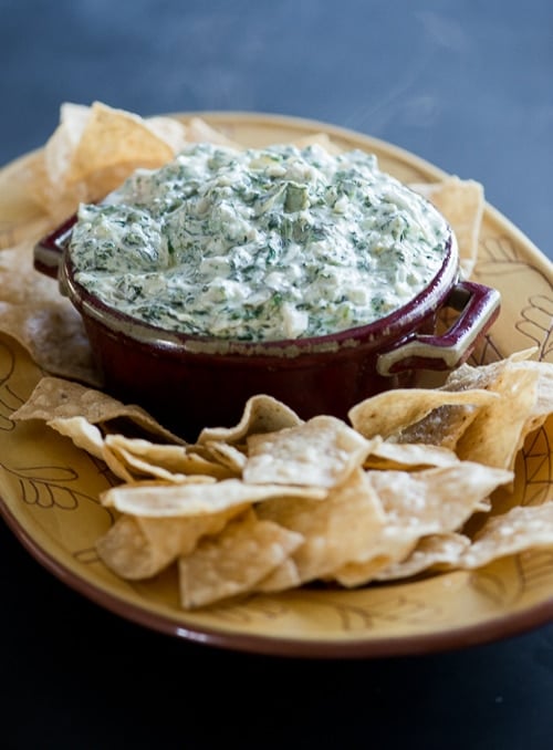 stove top Artichoke Spinach Dip on a platter with tortilla chips