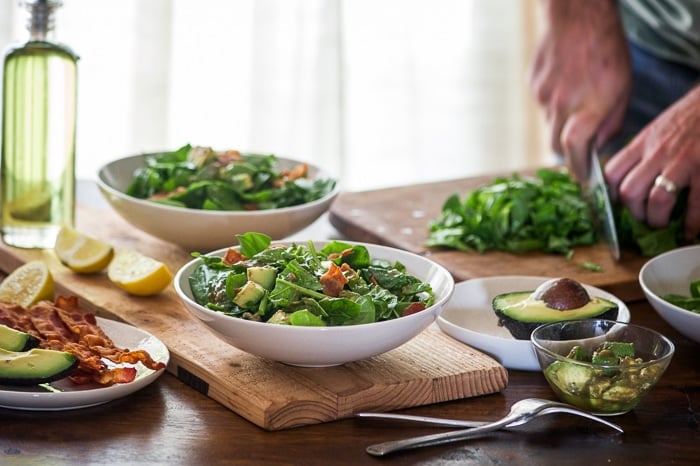 Bacon Spinach Salad with Amazing Avocado Vinaigrette in a bowl