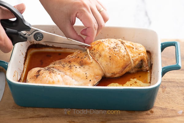 cutting strings on the cooked turkey breast