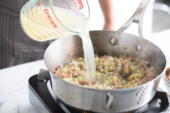 pouring broth into stuffing