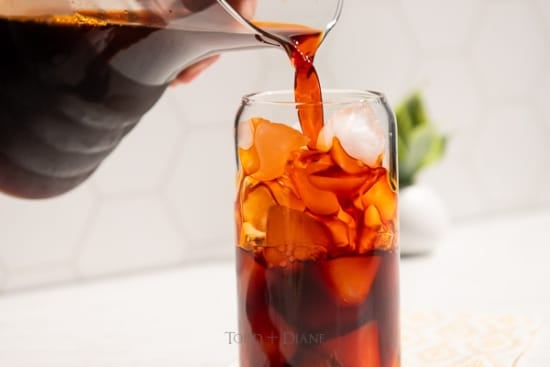 Pouring thai tea into glass with ice