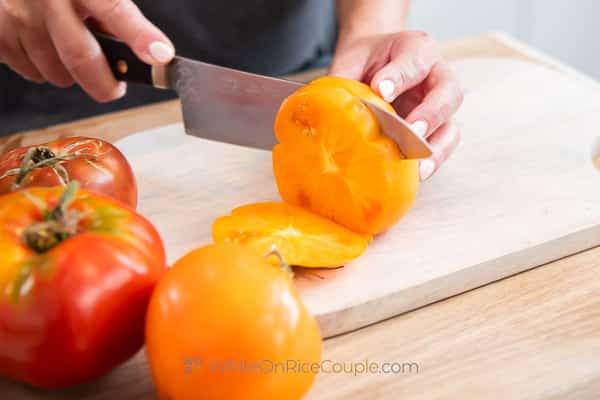 cutting thick slices of heirloom tomato