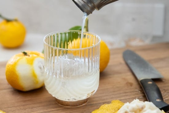 Straining cocktail into glass with ice