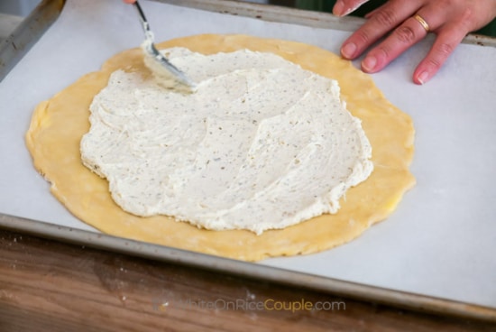 spreading cheese over pie dough